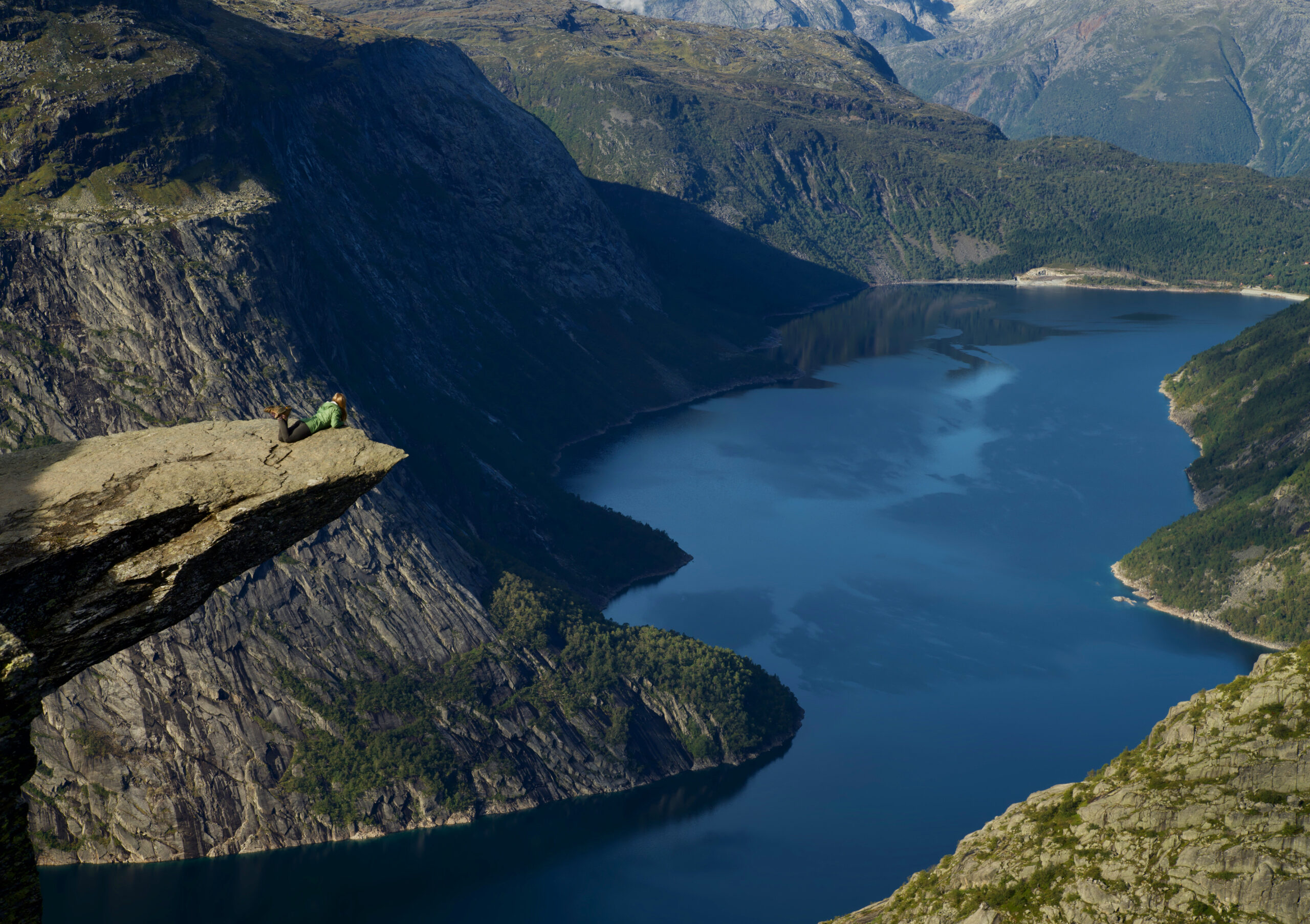 Janel laying down on Cliff looking down at Fjord