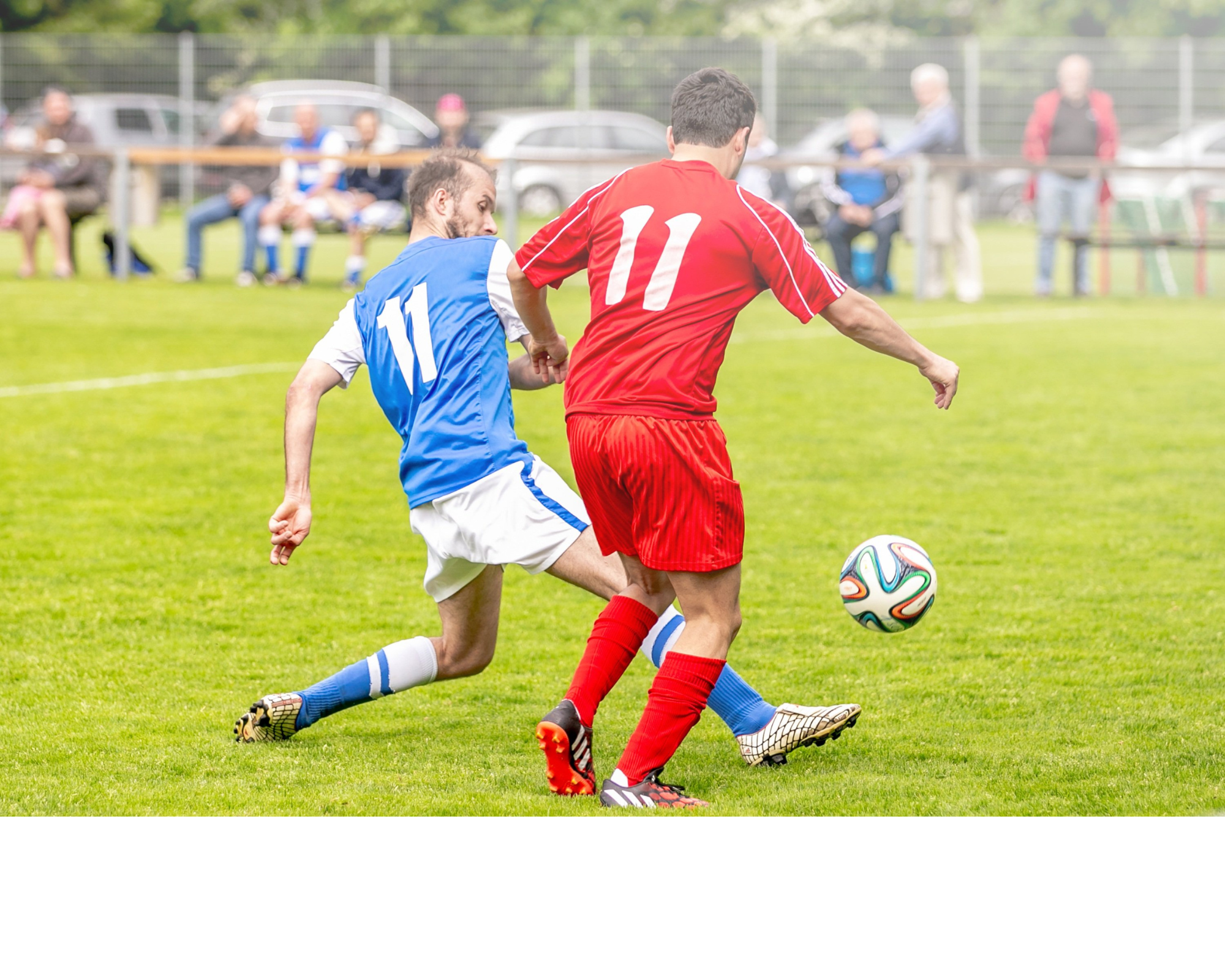 Male soccer players on opposing teams going for soccer ball